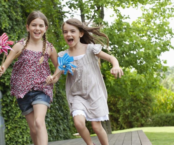 Girls running holding pinwheels